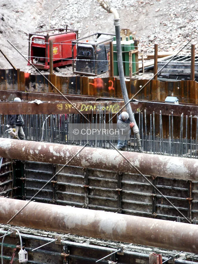 Worker pouring concrete into the foundation
