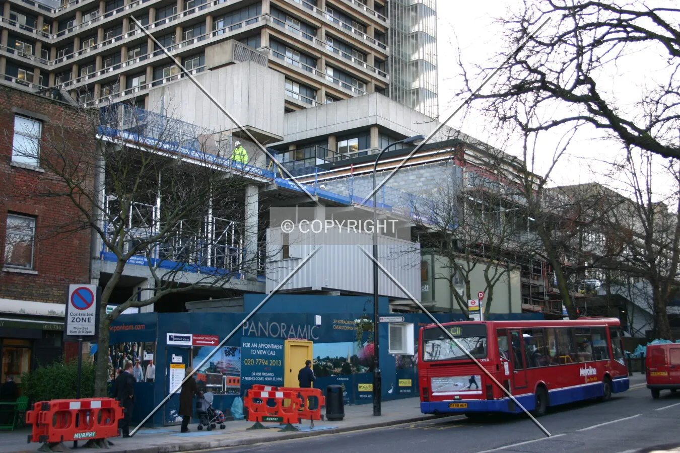 The first floor structural concrete rising above the hoarding from South End Green