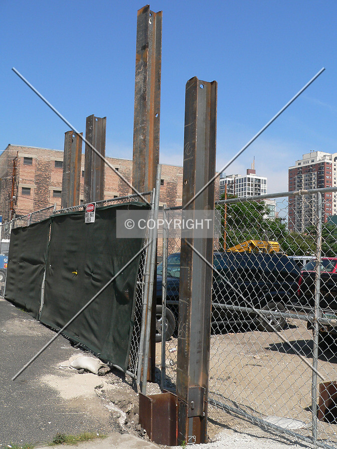 A row of steel pilings sticking out of the ground