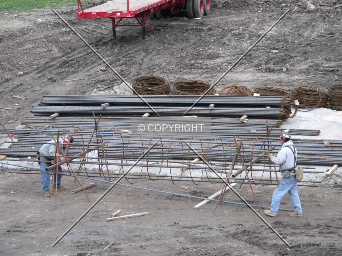 Workers assembling steel rebar cages that will help to form caissons