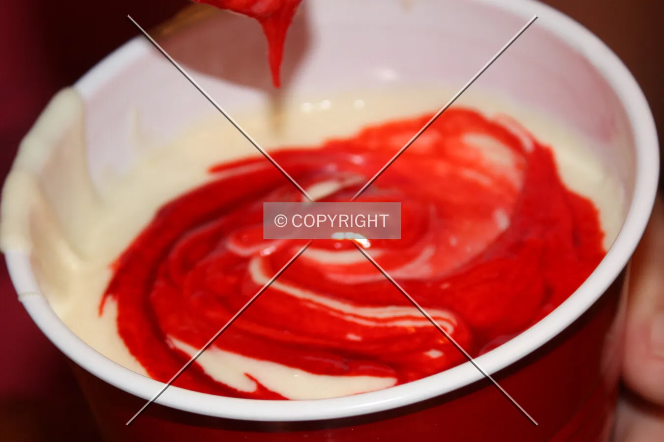 Red dye being mixed into cupcake batter