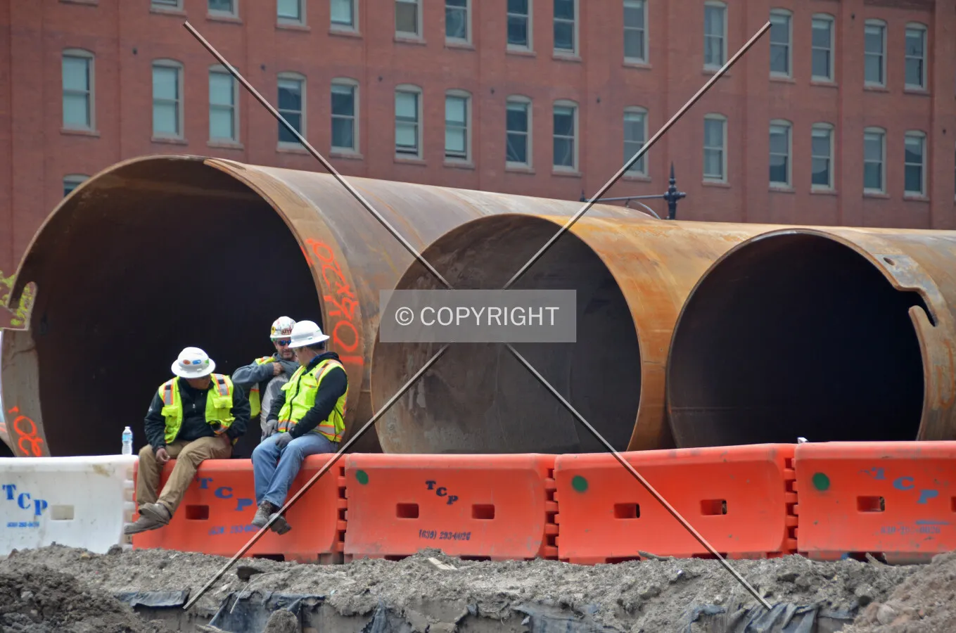 Workers sitting beside the large caisson 'tops' used to hold back soil during drilling. May 20, 2016