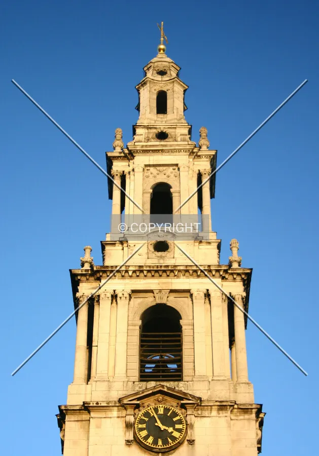 View northeast along the Strand of the top of the tower lit gold by the evening winter sun