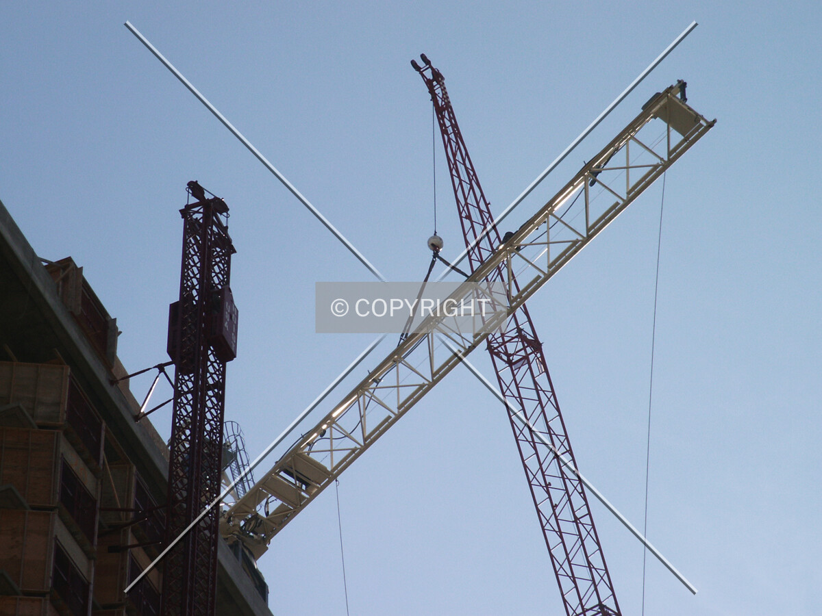 Movable crane hanging onto the foreboom of the tower crane