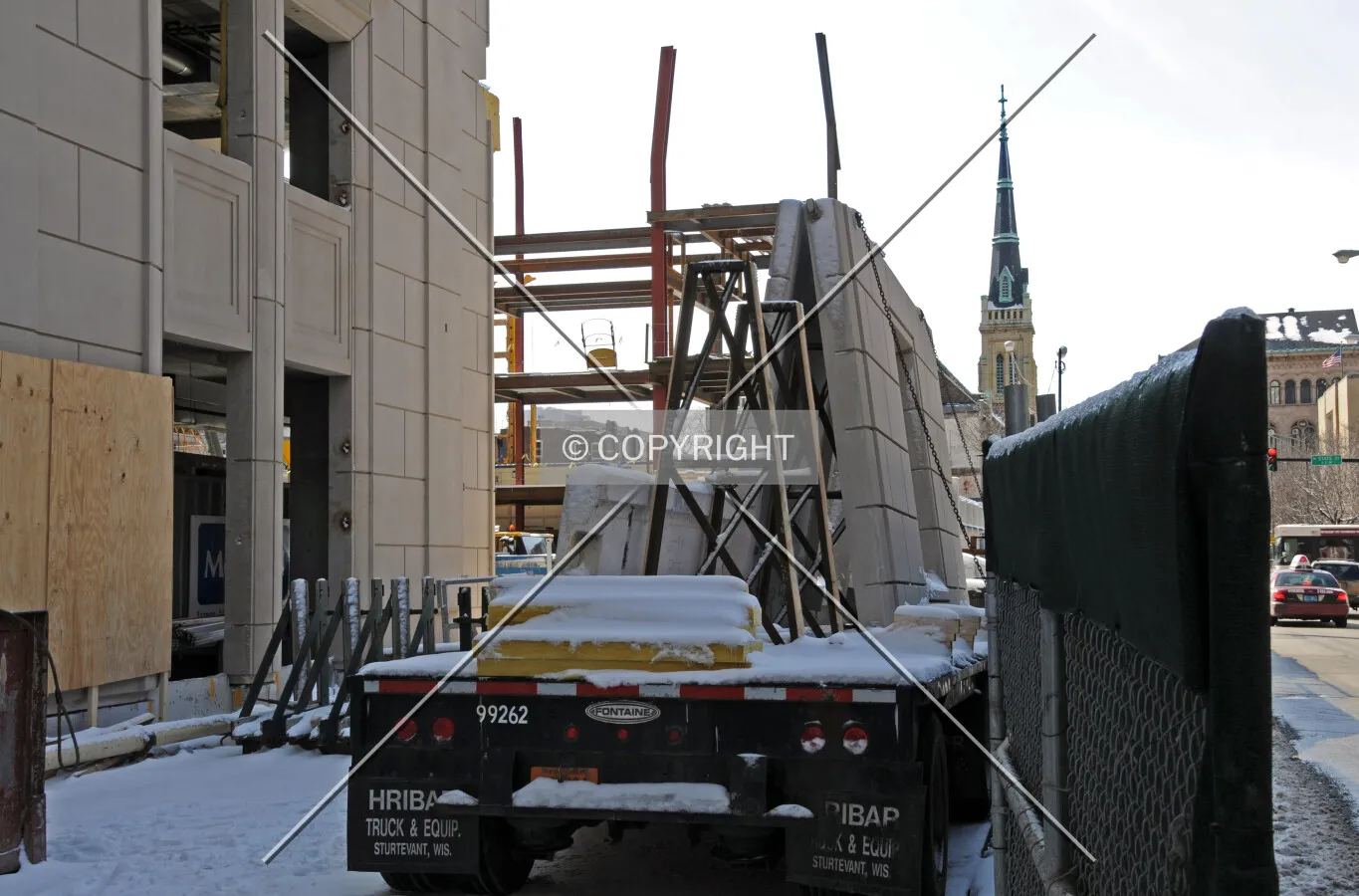 Flatbed truck along Walton Street with precast concrete facade panels waiting to be removed