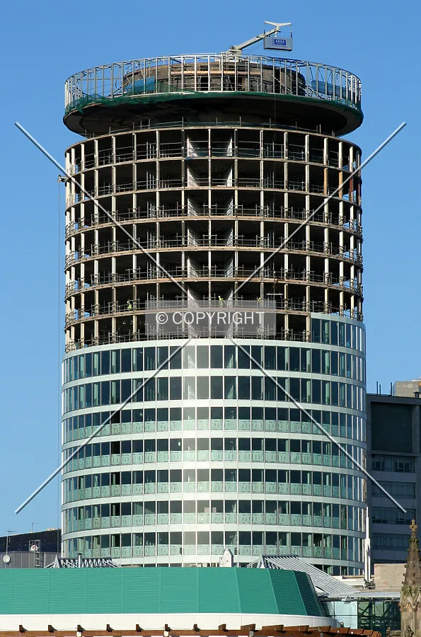 Full-height view showing facade installation progress