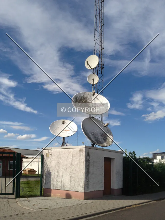 A small container building with a lot of satellite dishes on the roof