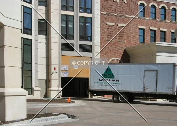 Unfinished garage entrance and new residents moving in, from Grant Street