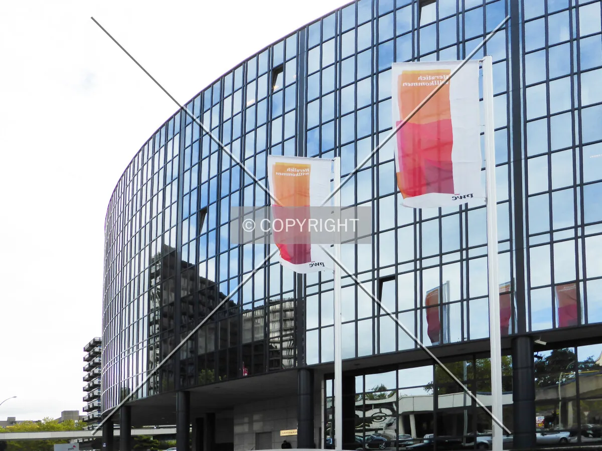 PWC flags in front of the glass facade