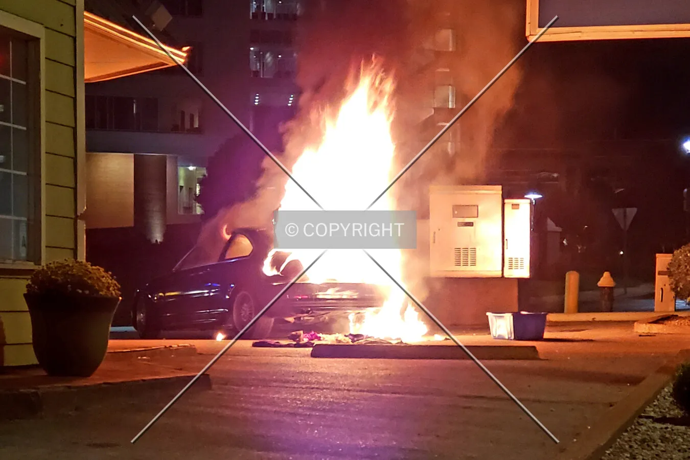 A car on fire in the parking lot at night; August 17, 2018