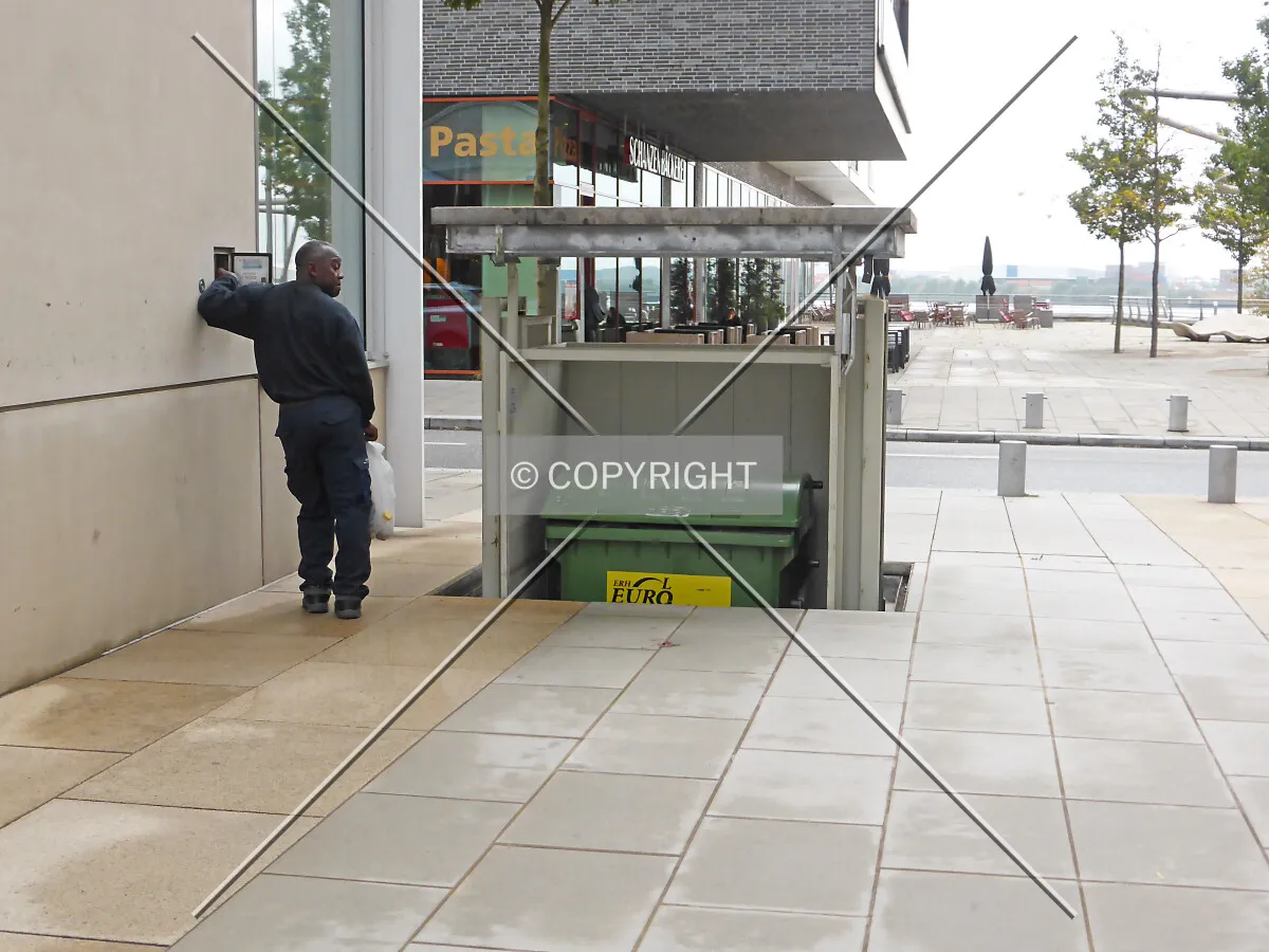 A garbage container is moved under the ground