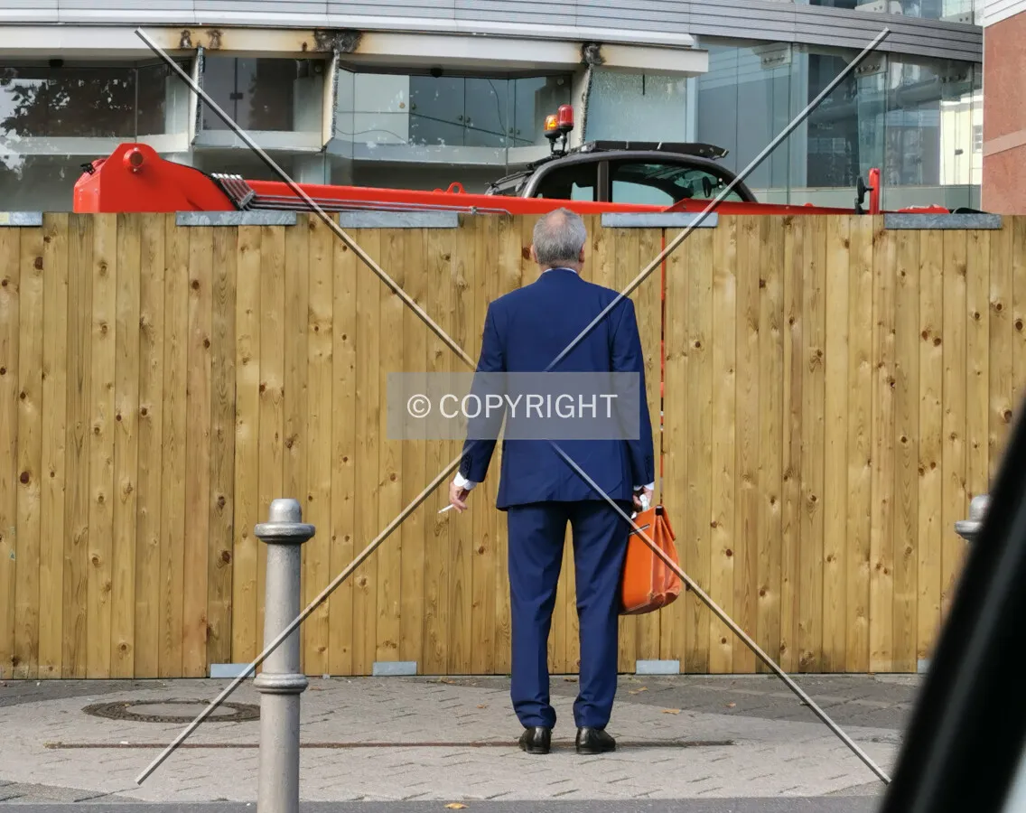 Business man standing in front of the MesseTurm in search of the entrance