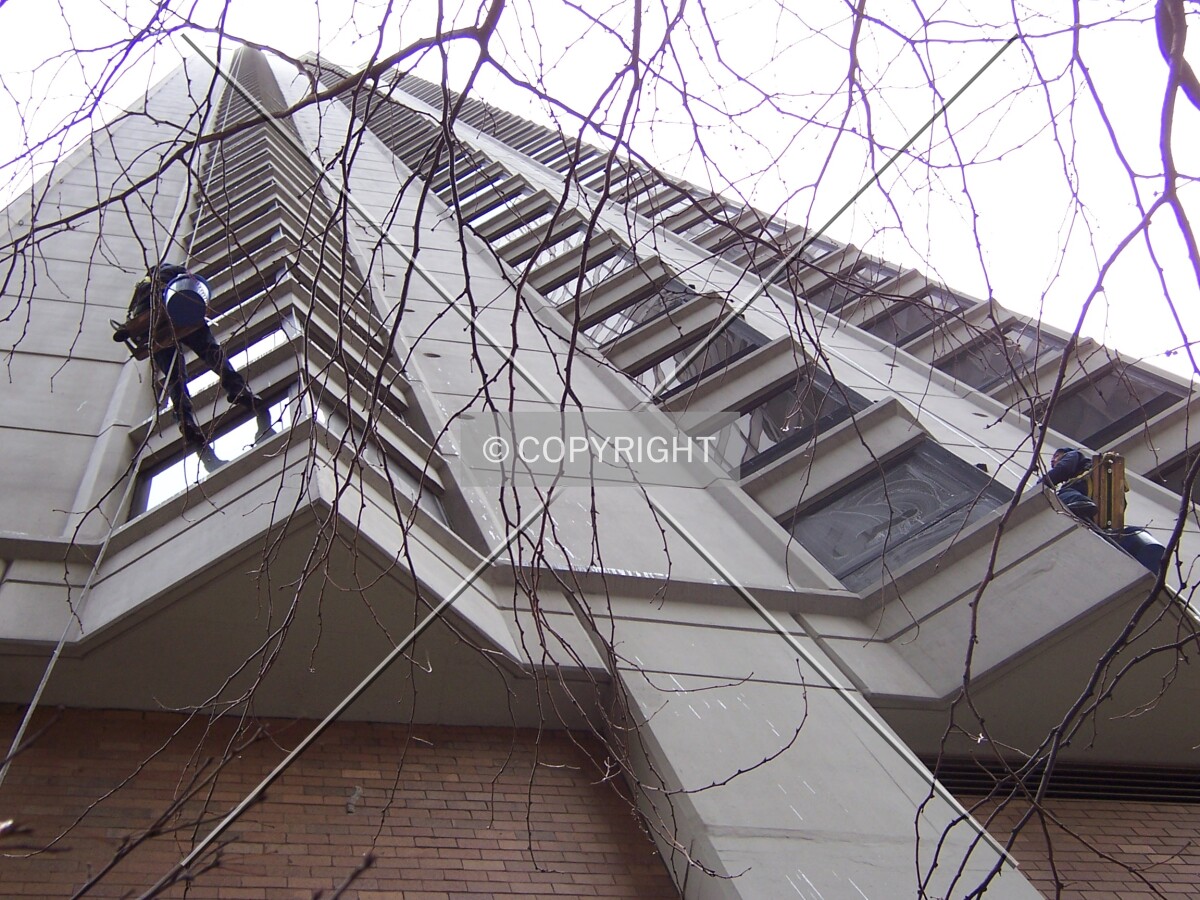 Window washers hanging on the west facade