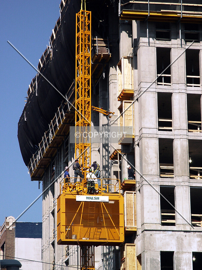 Workers standing on top of the hoist
