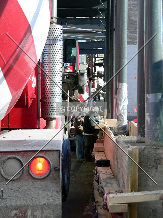 Concrete trucks lined down the alley as the protective barrier is worked on