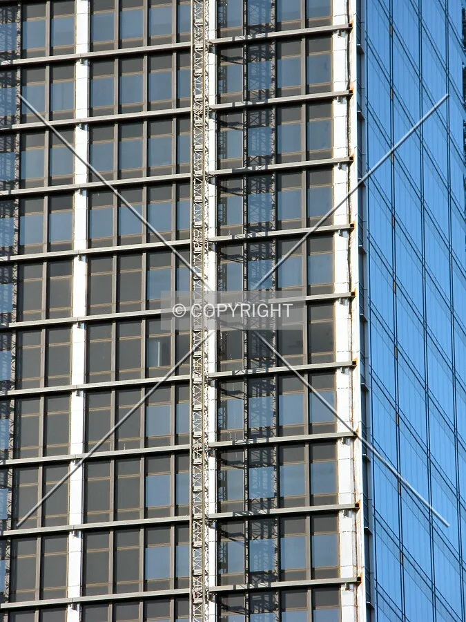 Detail of the northeast corner with the original black facade, framing for the new facade, and completed new facade on the right