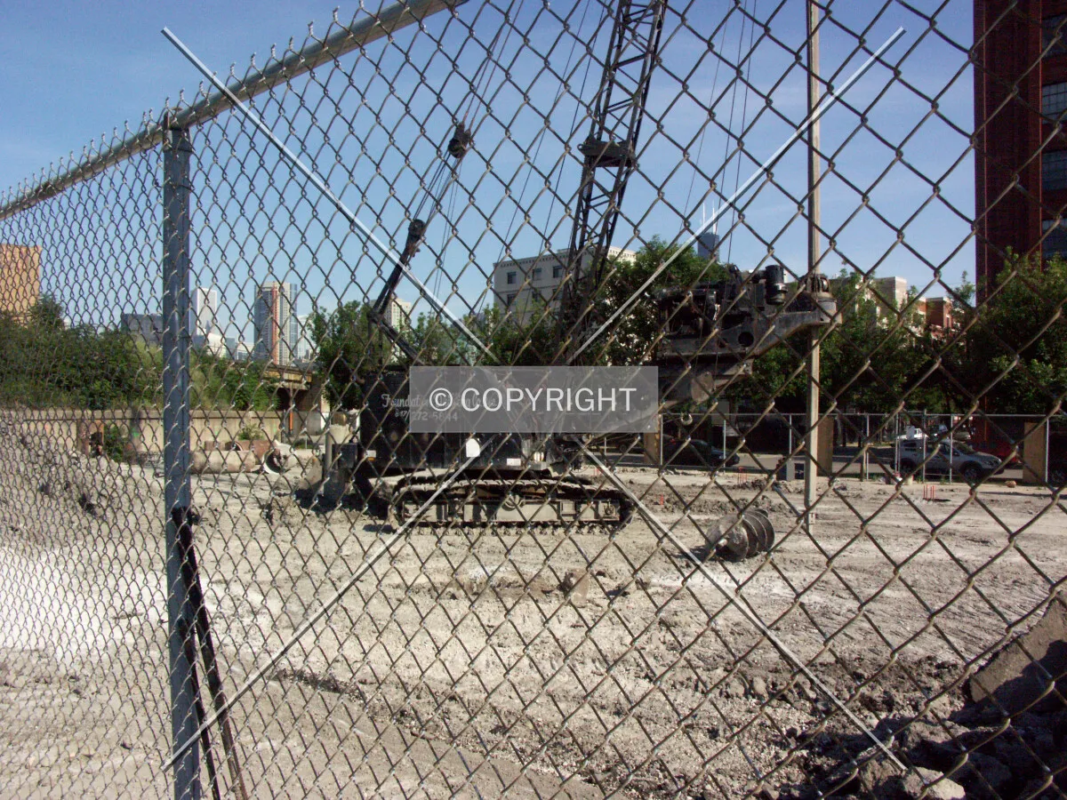 Caisson drilling crane viewed through the north fence