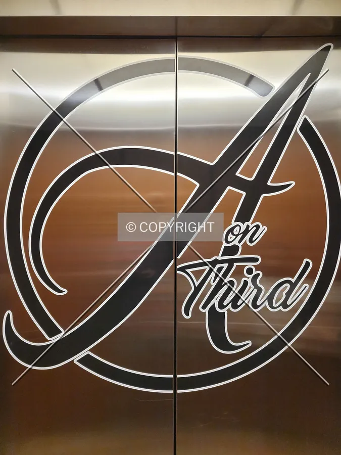 Hotel logo on the interior of the elevator door; March 19, 2021