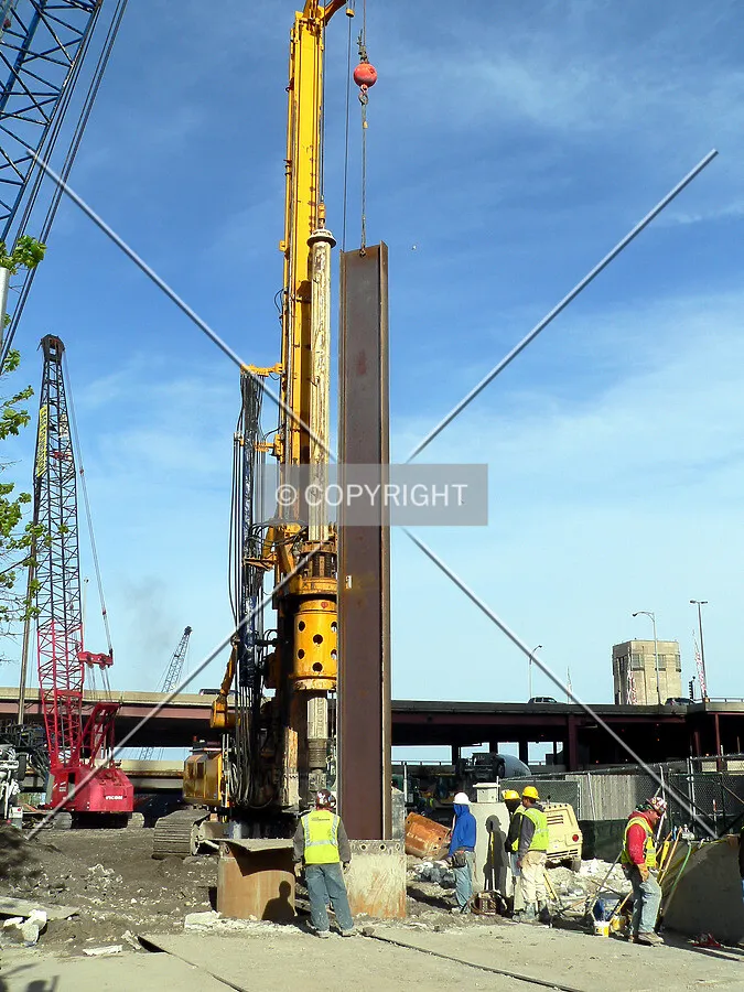 Lowering a steel beam into a secant pile hole