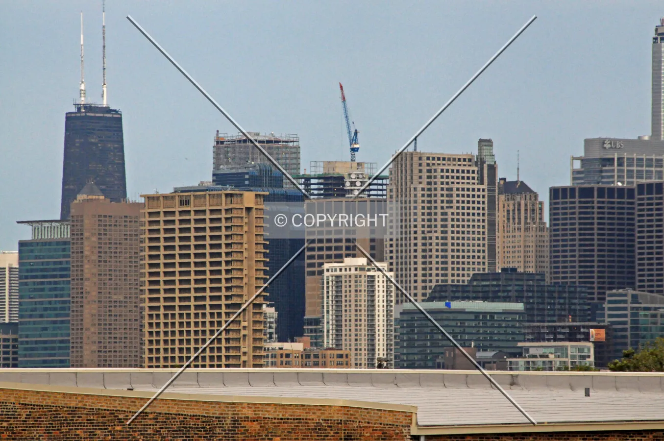 Looking northeast from the CTA 18th Street Pink Line Station at the concrete core and tower crane rising above the skyline canopy
