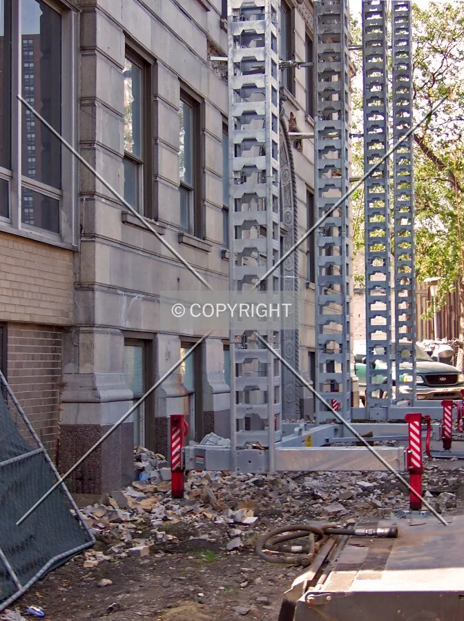 Looking west along Foster Avenue. Scaffolding structure stands parallel to the base of the mid-rise tower during the begining stages of demolition