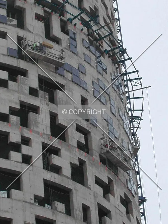 Workers installing windows in the second section of the building