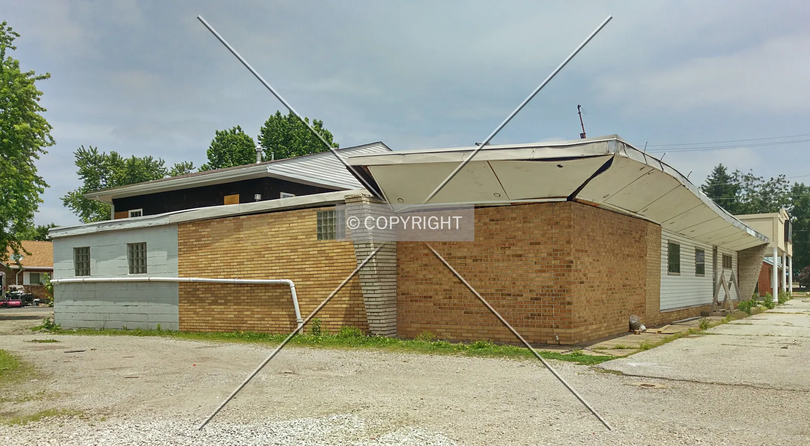 View from the southwest with roof damage; June 3, 2015