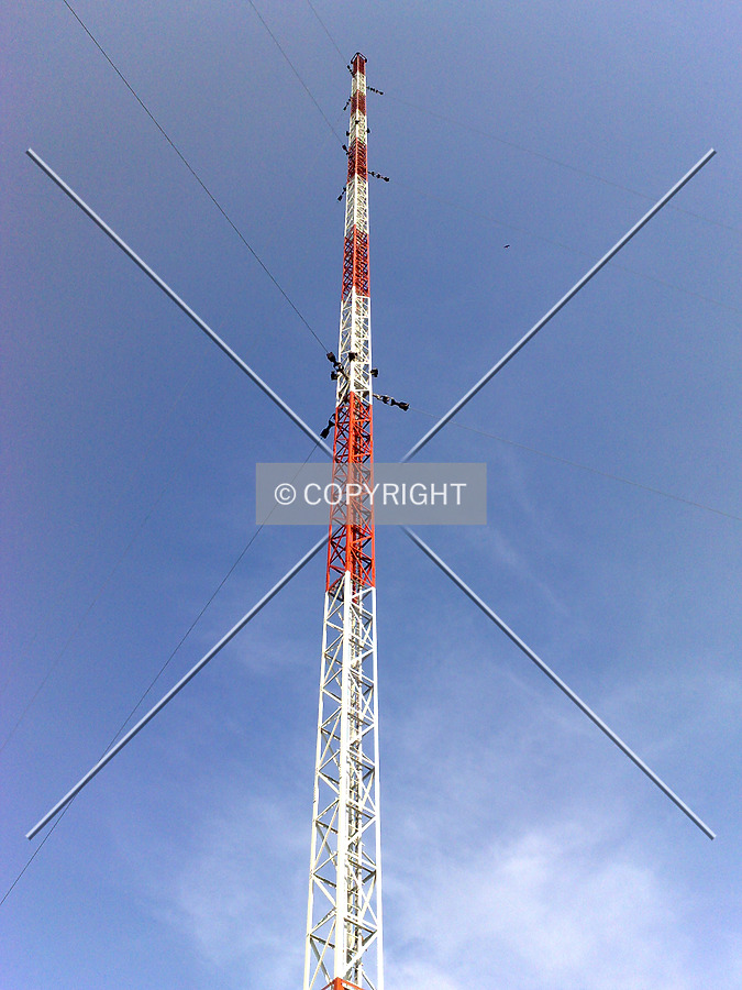 Looking up the red and white colored radio mast