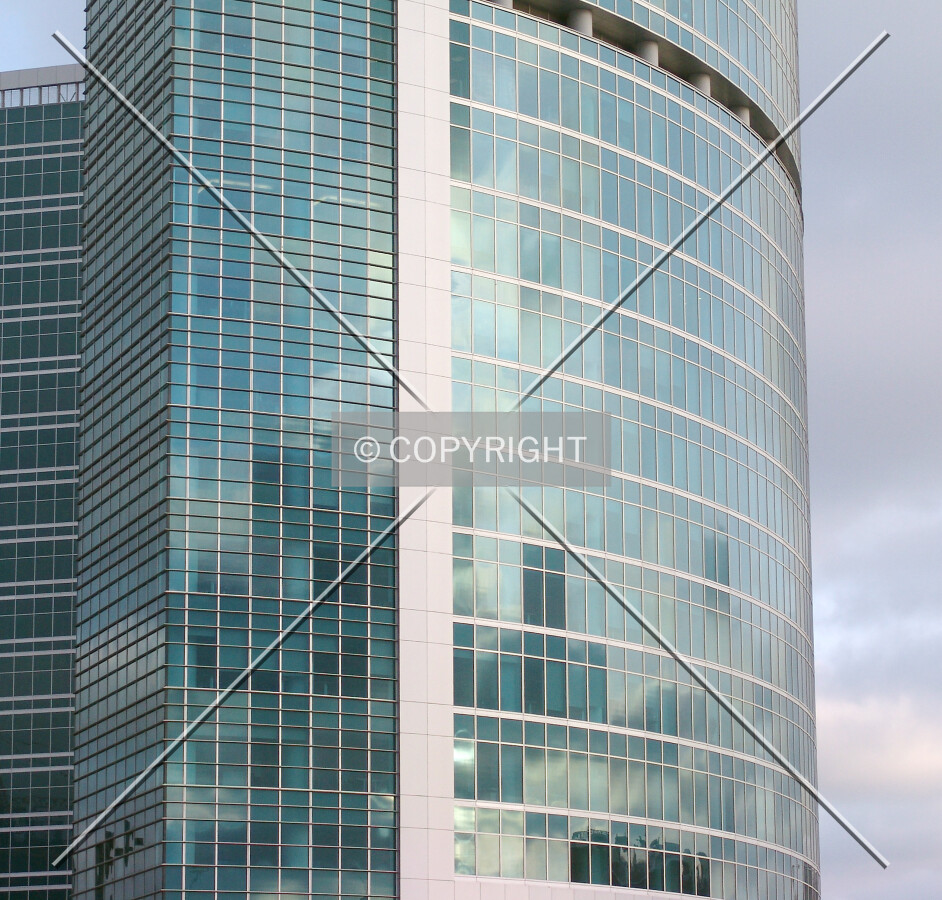Glass facade reflecting cloudy sky