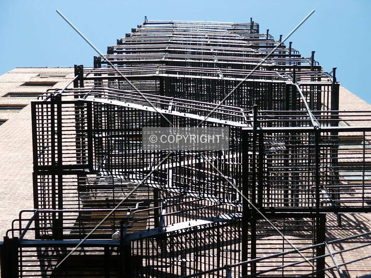 Looking up the east fire escape from the alley