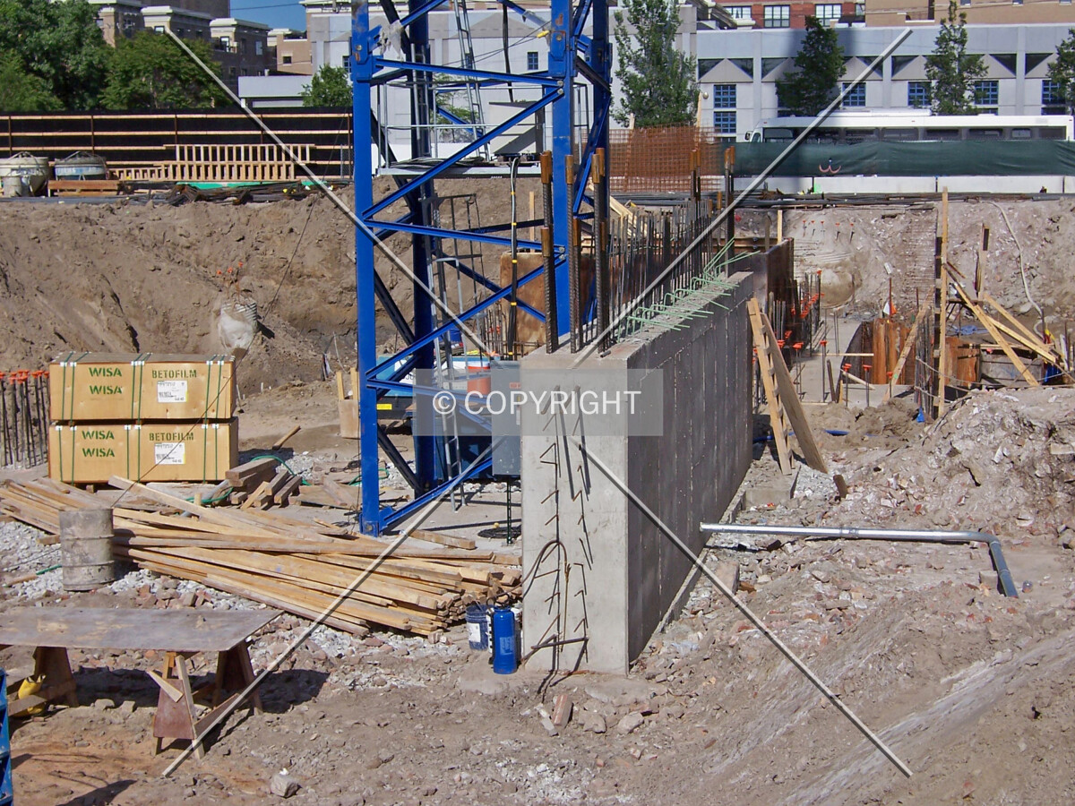 The base of the tower crane and an adjacent foundation wall