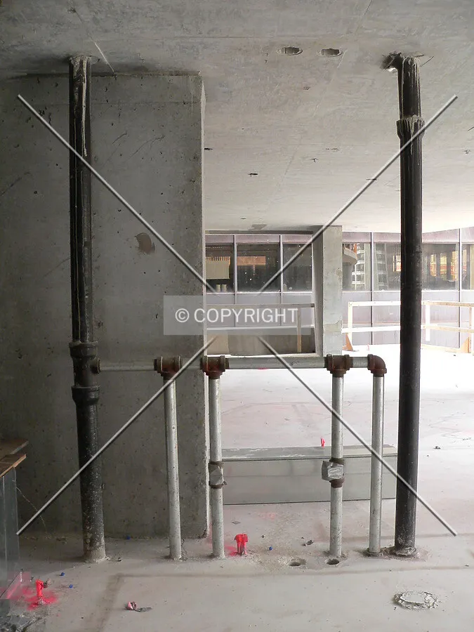 Inside one of the units with pipes moving up through the structure