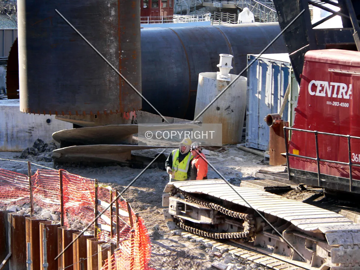 Construction workers standing by as a caisson liner is ready to be lowered into position