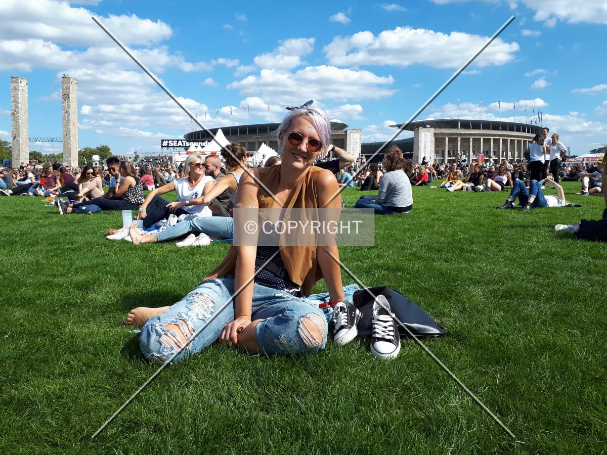 A woman relaxing in front of the Olympic Stadium in Berlin preparing for a music concert