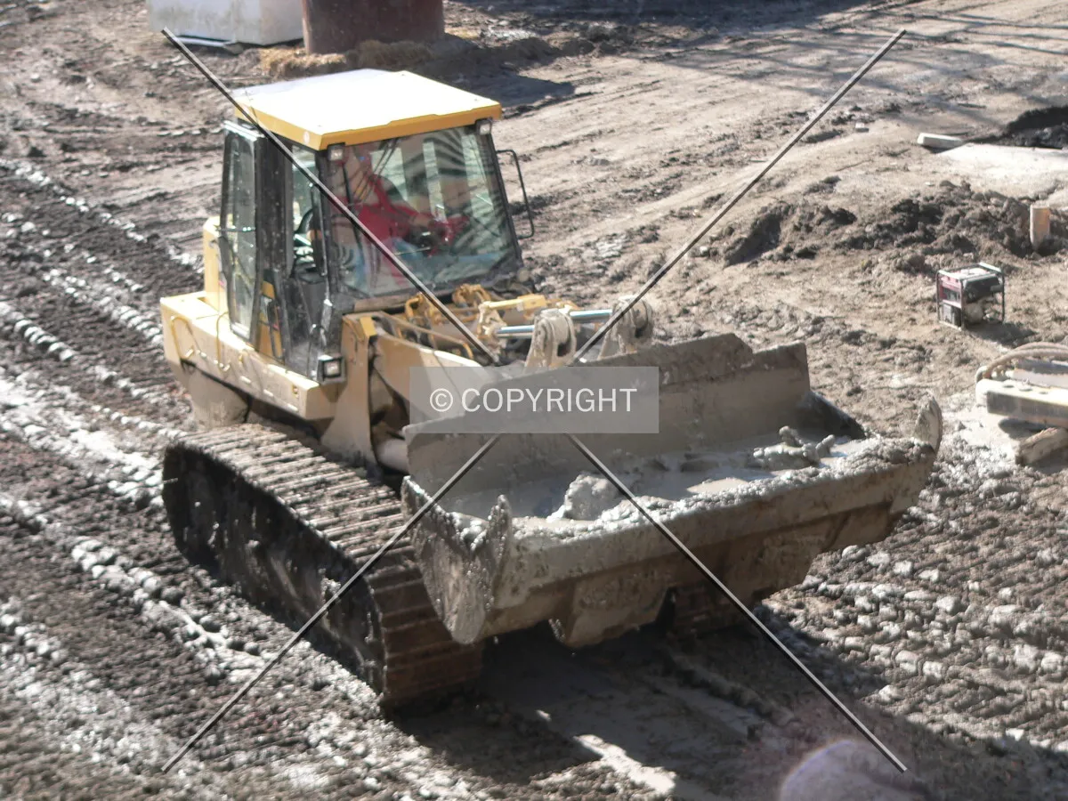 A front loader removing clay from the site