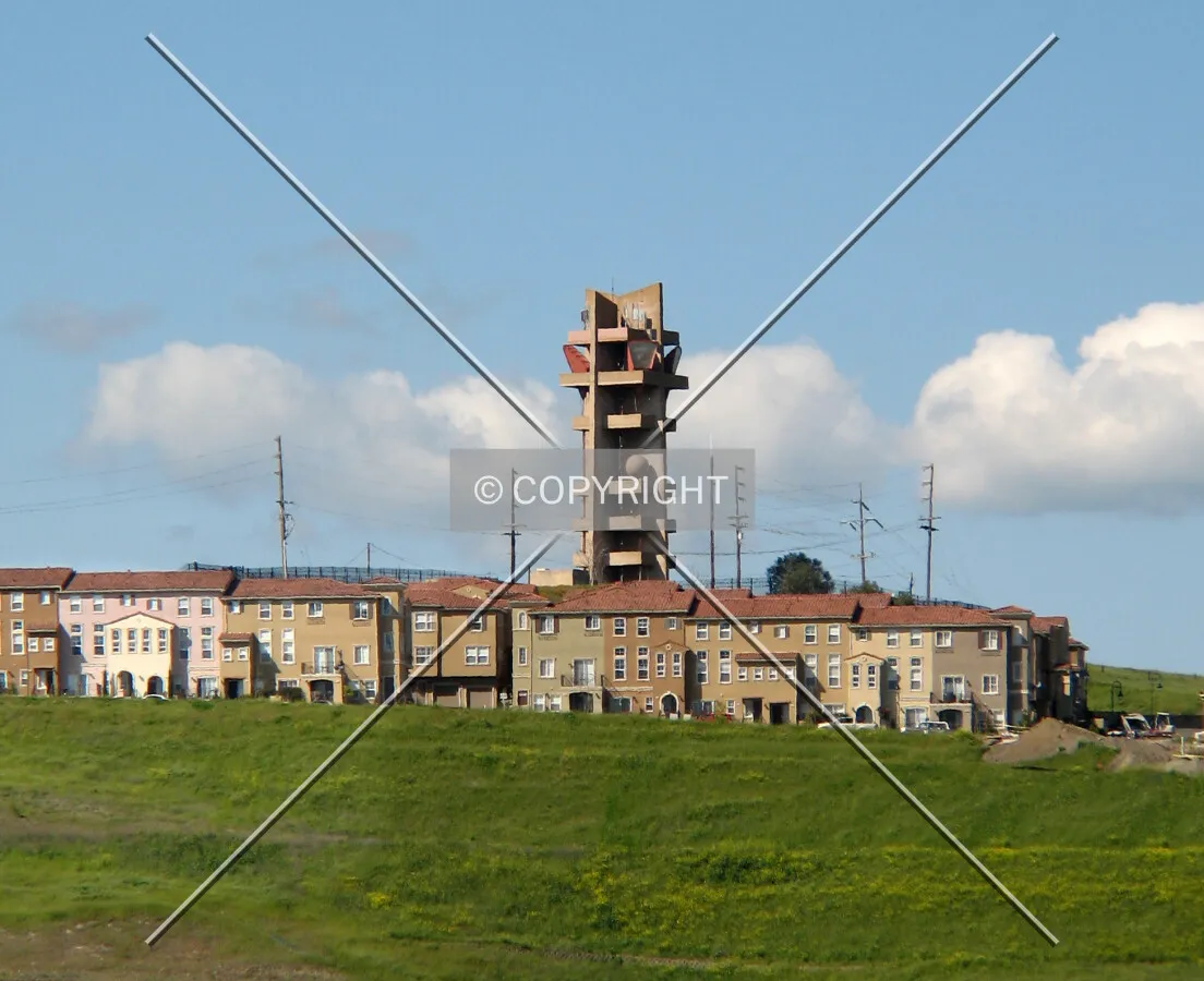 The tower rises above the surrounding houses and condos, seen here from the south