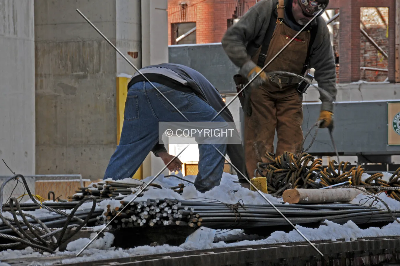 Workers unloading rebar from a flatbed truck along Rush Street