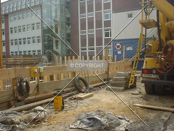 Concrete mixer standing nearby excavation hole