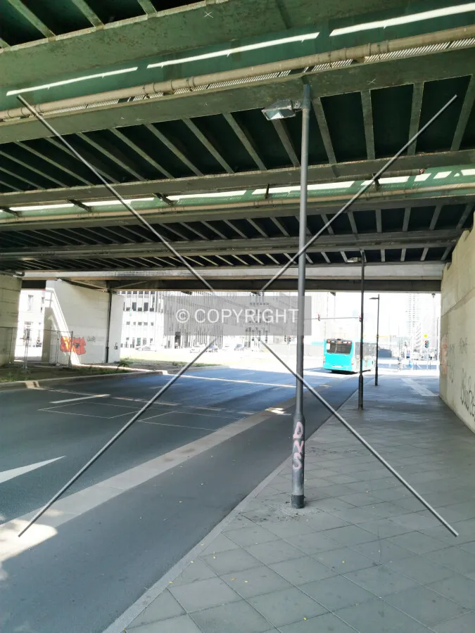 A street lamp located under a bridge