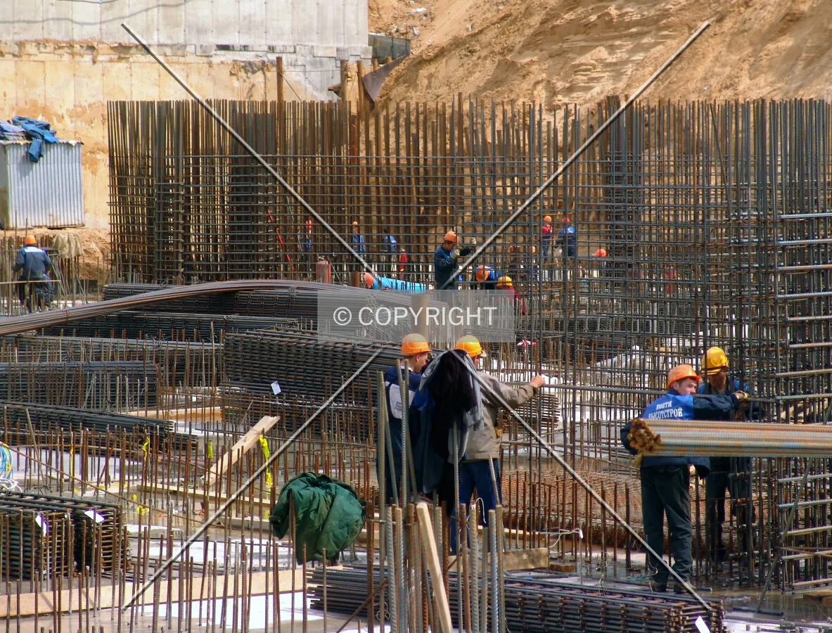 Workers standing in a forest of rebar