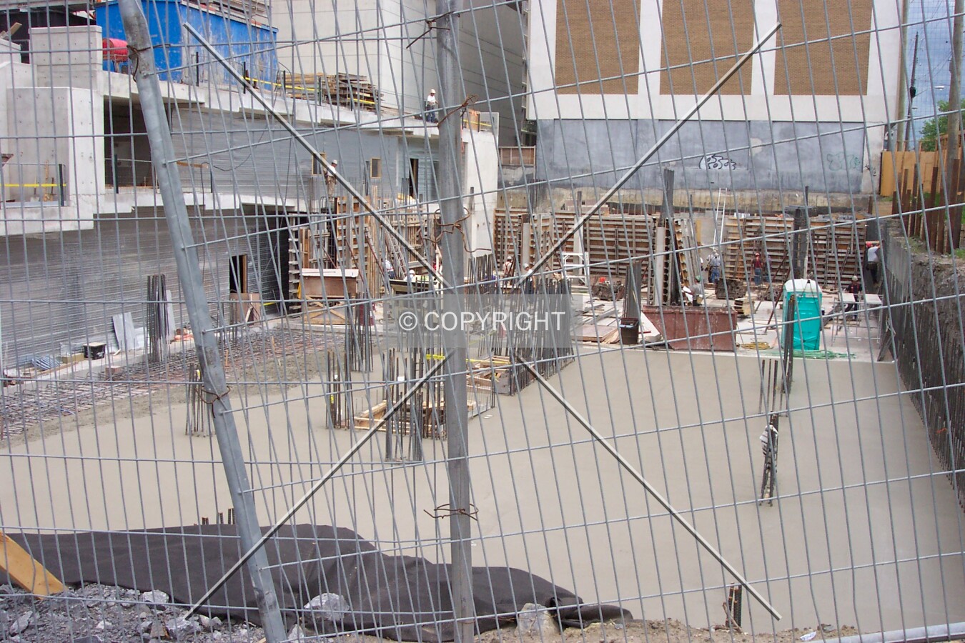 Looking through the fence at the poured foundation
