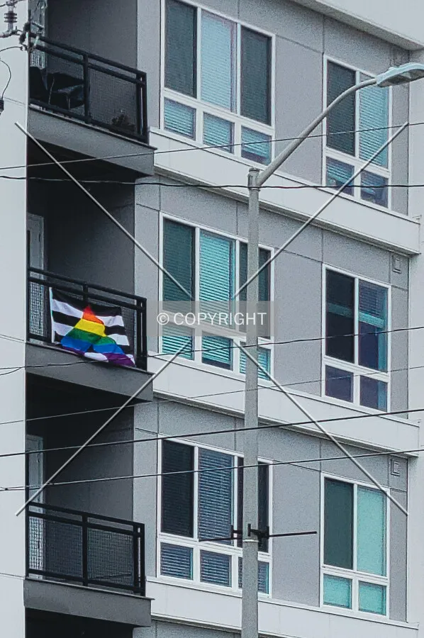 A pride flag hanging off a balcony on the south side; June 26, 2021