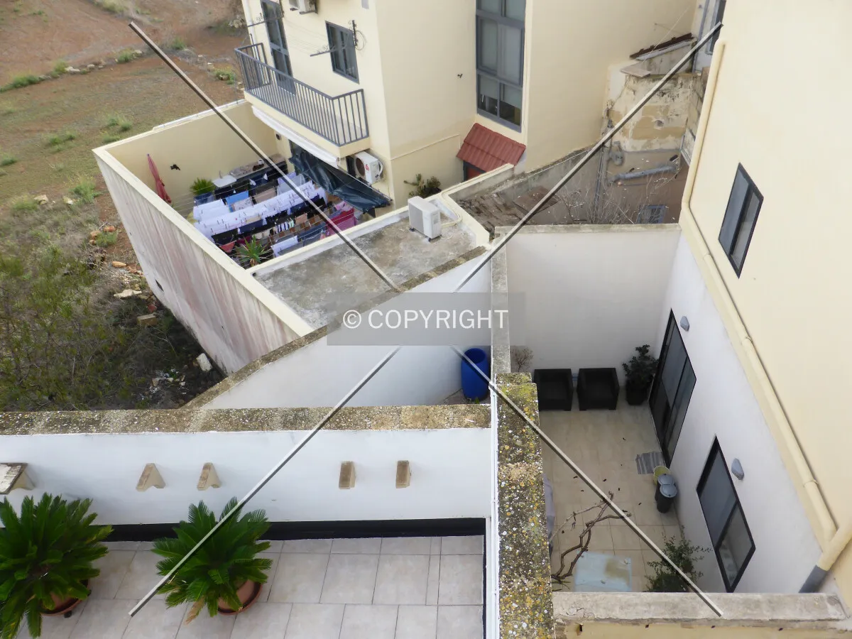 Typical maltesian architecture in Il-Gudja, Malta - where average people live. Here you see a fenced courtyard surrounded by tall walls.