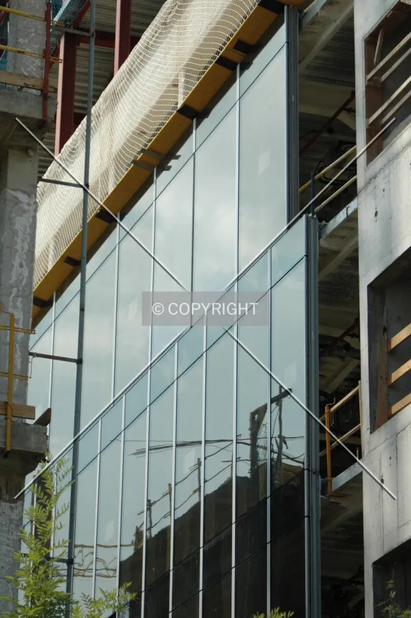 Glass facade on the south side facing an old low-rise building being refurbished