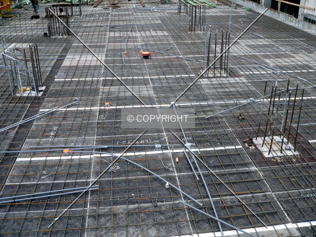 View of formwork decking for a lower level with rebar and the tops of columns visible