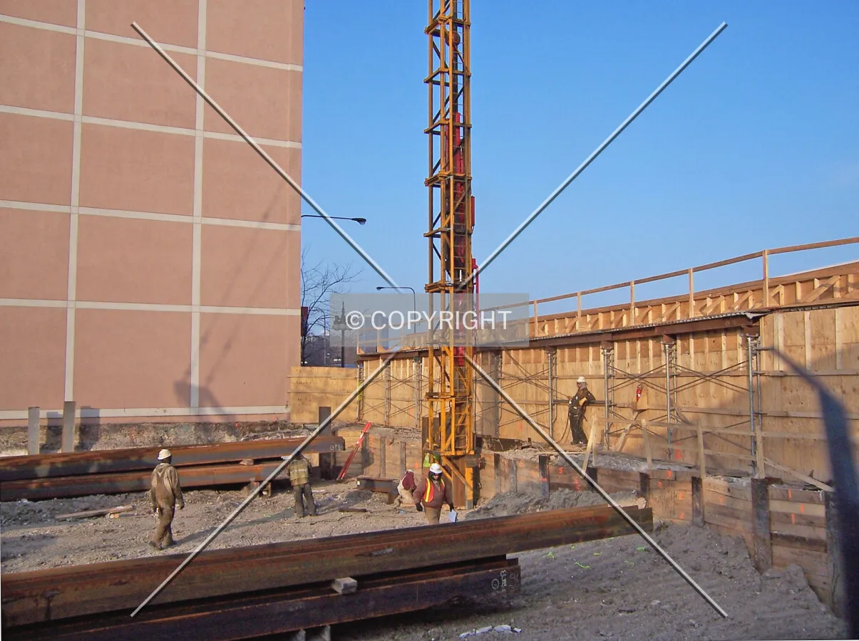 A pile driver at work on the eastern edge of the site. Yet to be used steel piles lie on the ground on each side of the pile driver