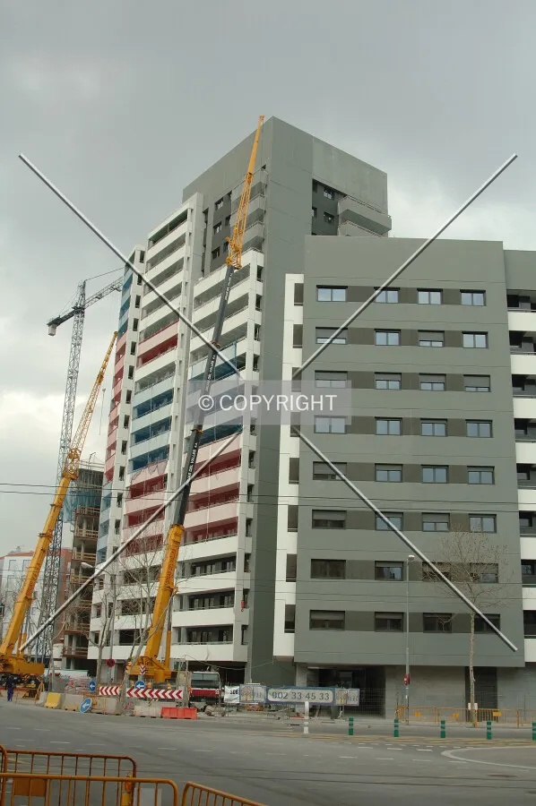 Two mobile cranes working on the facade