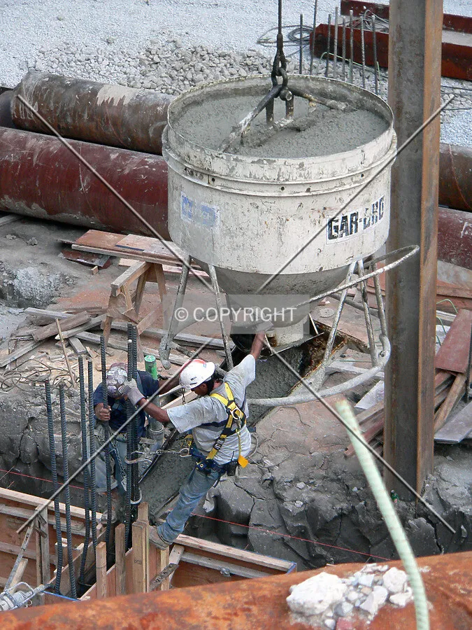 Workers filling formwork with a load of concrete