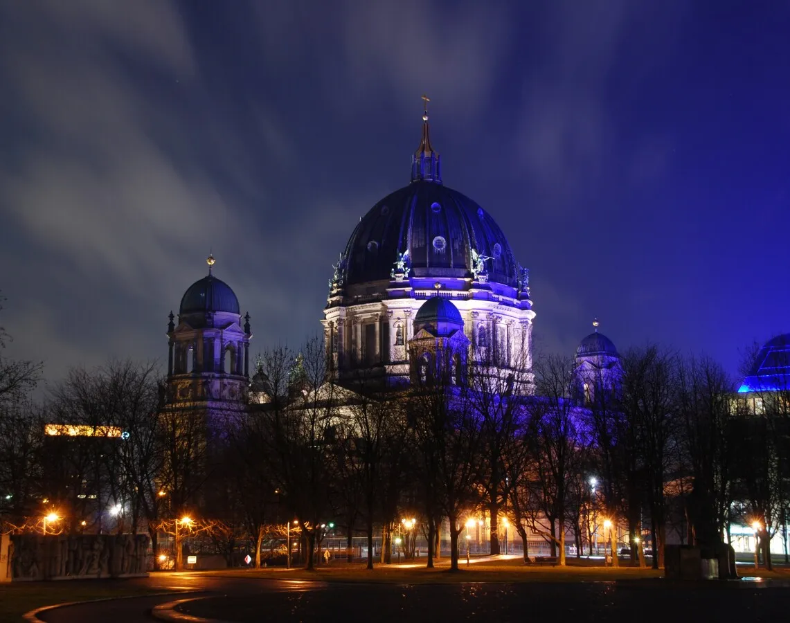 The main dome behind trees bathed in blue light
