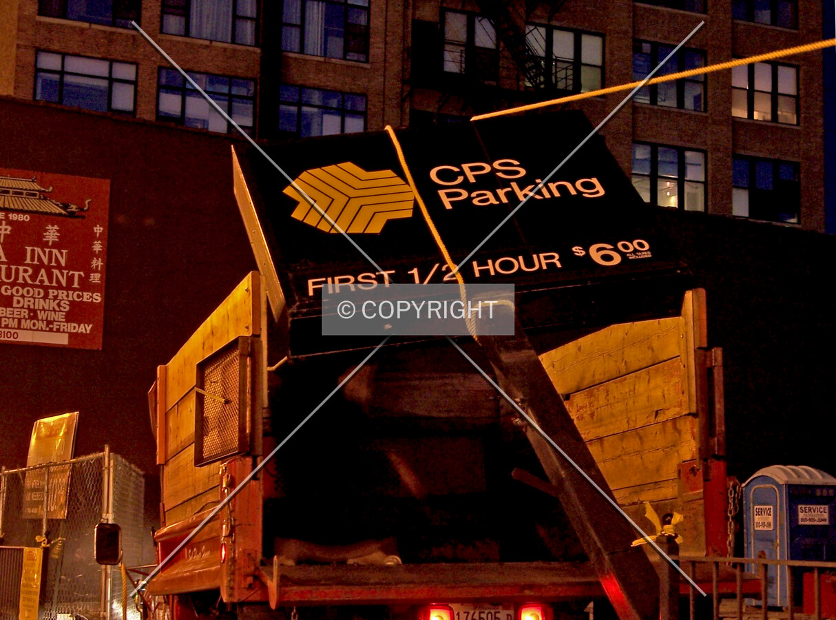 Workers placing the removed sign from the former surface parking lot into a truck